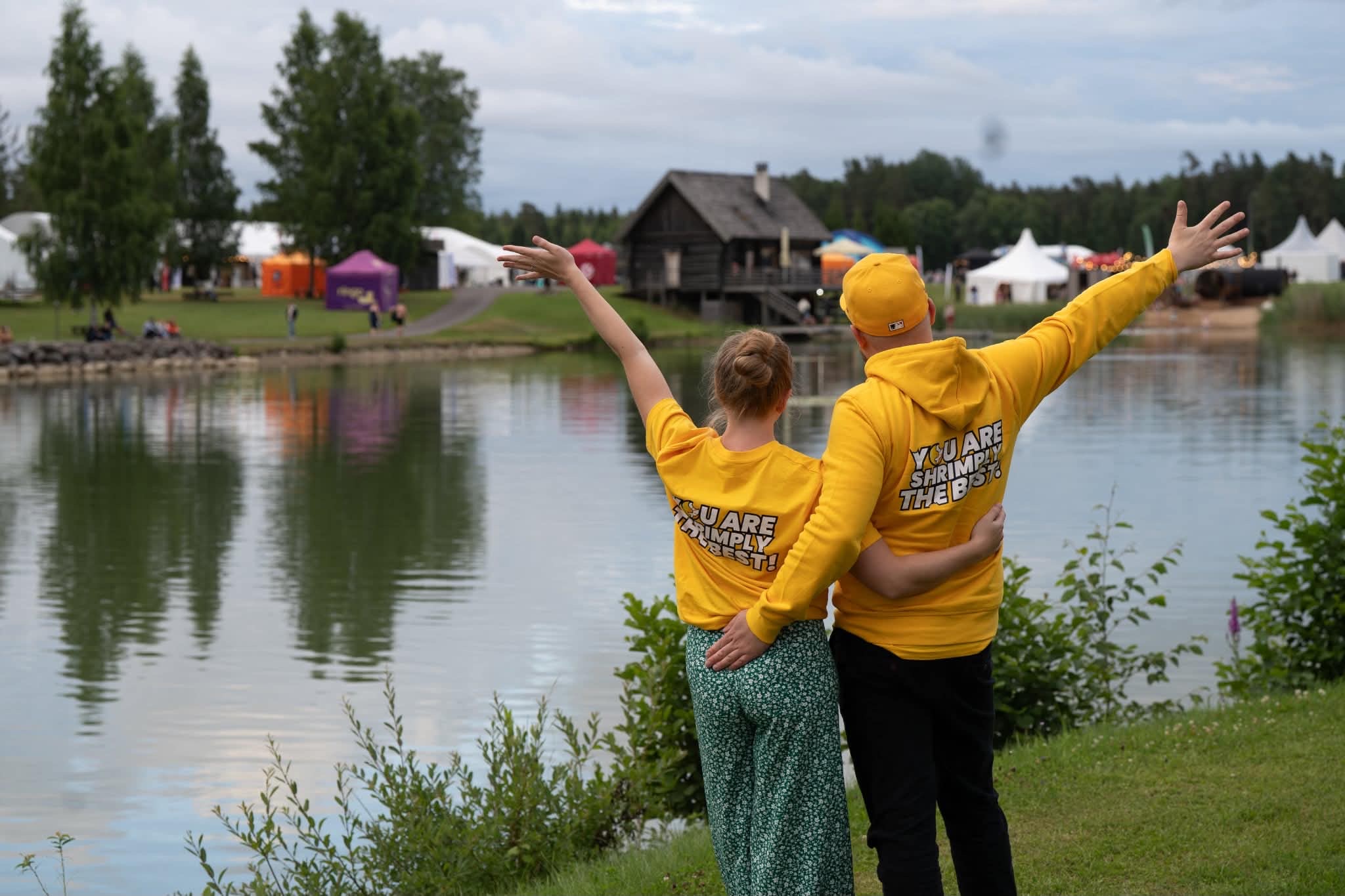 Tõnis-Denis and Pille-Riin in yellow TAILBITE’S® hoodies by a lake